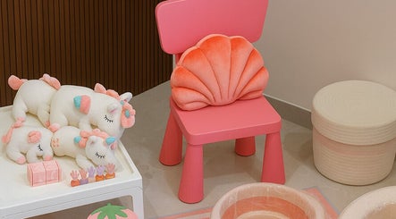 A cozy pink chair with plush unicorns at زوز للعناية النسائي - Zooz care, Riyadh, Riyadh Province, SA.
