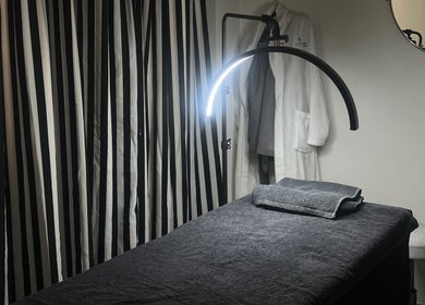 Relaxing spa room at Saseka Co., Pretoria, Gauteng, ZA, featuring cozy treatment bed and elegant striped curtains.