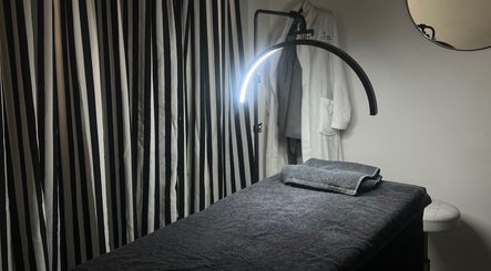 Relaxing spa room at Saseka Co., Pretoria, Gauteng, ZA, featuring cozy treatment bed and elegant striped curtains.