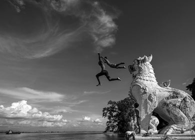 Two kids leap into a river from a lion statue near B M Co, Tanauan City, Calabarzon, PH.