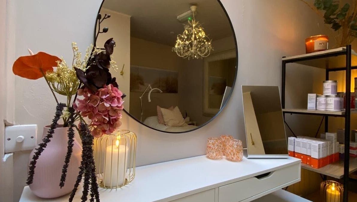 Elegant beauty room at Glow by Siobhan, The Gym, Howth, Dublin with candles, flowers, and a round mirror.