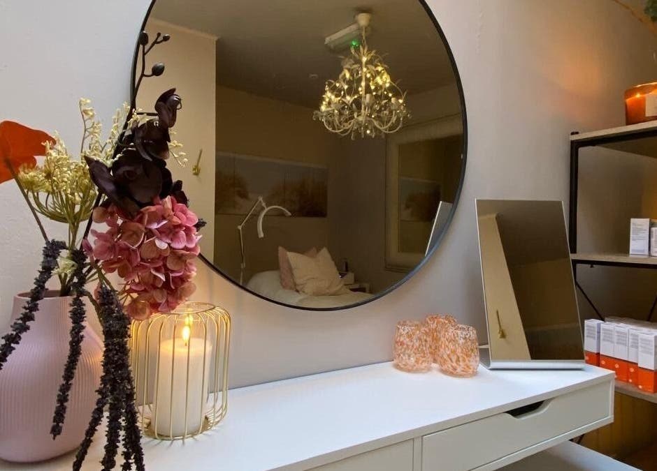 Elegant beauty room at Glow by Siobhan, The Gym, Howth, Dublin with candles, flowers, and a round mirror.