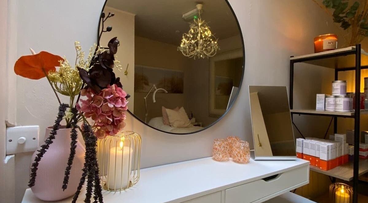 Elegant beauty room at Glow by Siobhan, The Gym, Howth, Dublin with candles, flowers, and a round mirror.
