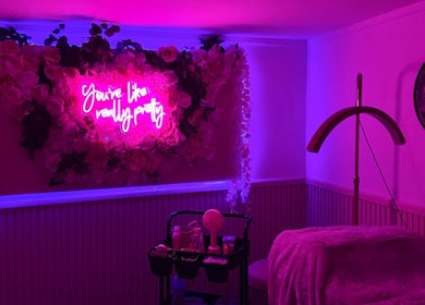 Cozy pink neon-lit room at Yourluxelounge, Kidderminster, England, GB with floral decor and beauty essentials.