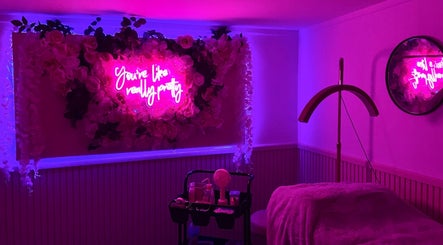Cozy pink neon-lit room at Yourluxelounge, Kidderminster, England, GB with floral decor and beauty essentials.