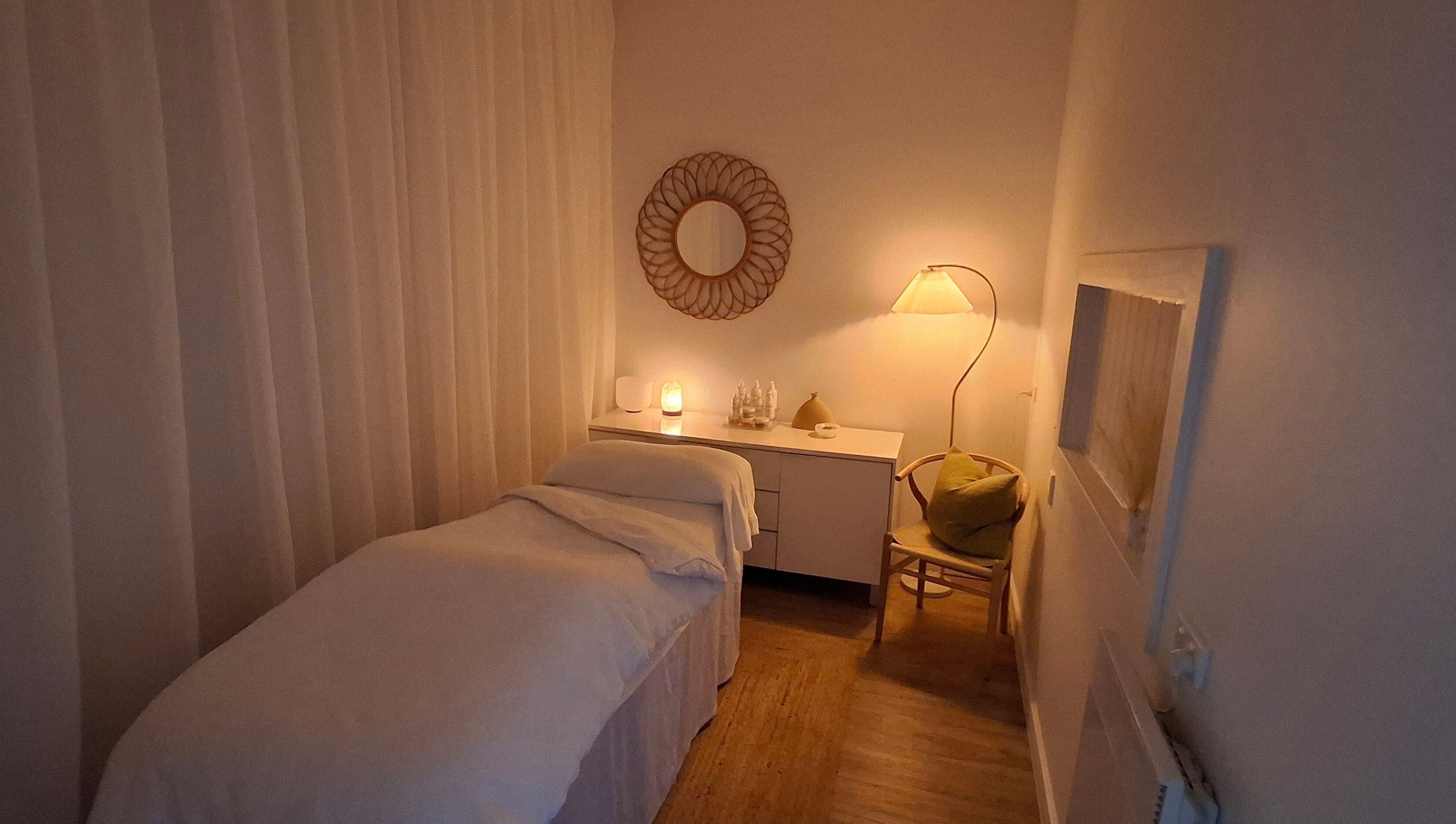 Relaxing massage room at Calma Studio in Melbourne, Victoria, AU, featuring soft lighting and a cozy bed.