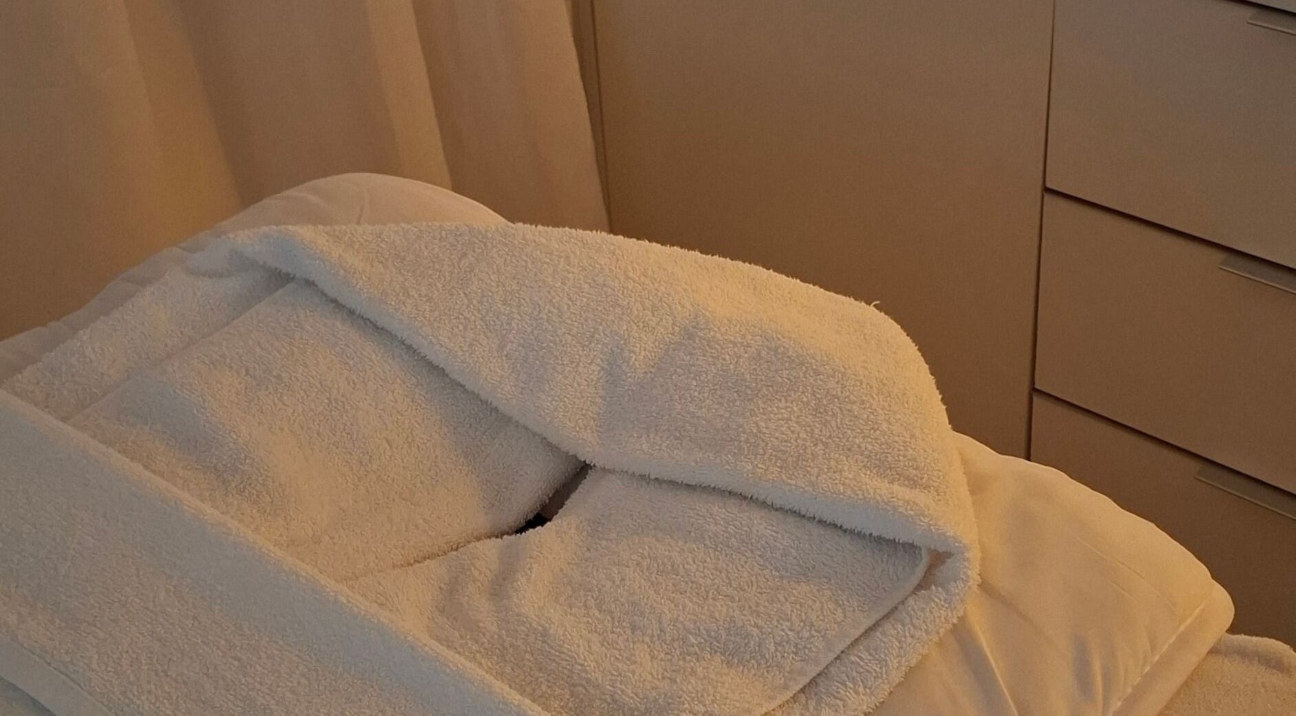 Calma Studio treatment bed with white linens in Melbourne, Victoria, AU, offering a tranquil ambiance.