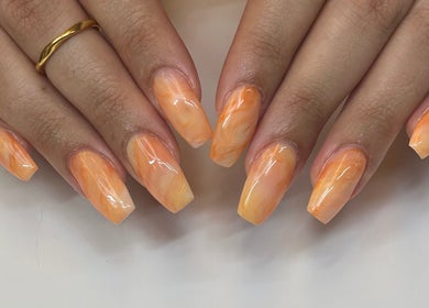 Manucure éclatante à Coralie Esthétique, Laval, Québec, CA, avec des nuances orange.