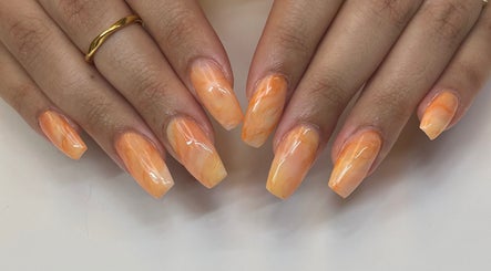 Manucure éclatante à Coralie Esthétique, Laval, Québec, CA, avec des nuances orange.