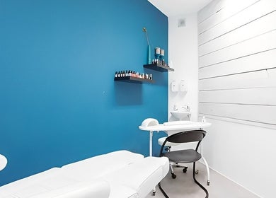Moderne behandelkamer bij Mixt Haarsalon in Haarlem, Noord-holland, NL met blauwe muur en verzorgingsproducten.