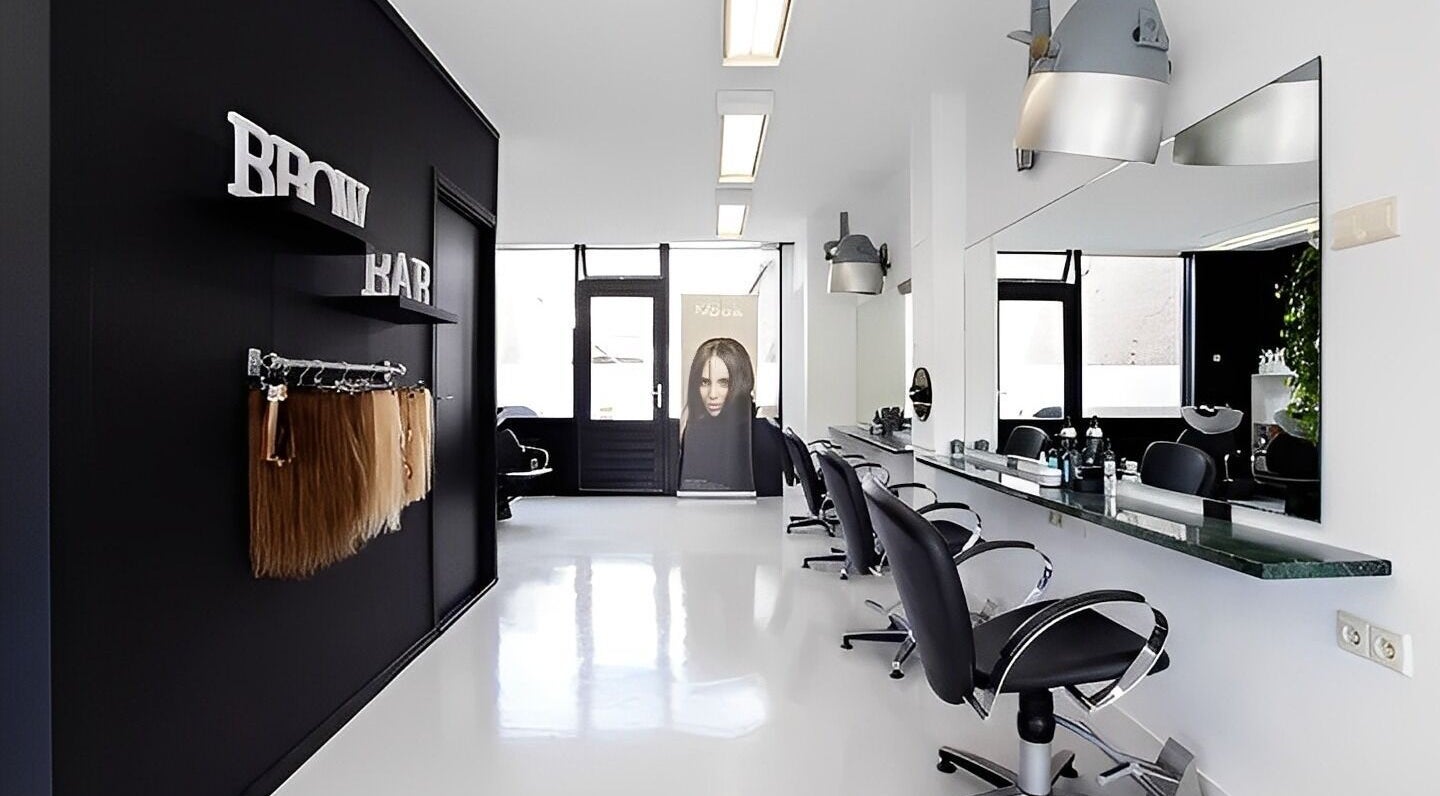 Interieur van Mixt Haarsalon in Haarlem, Noord-holland, NL, met moderne kappersstoelen en spiegel.