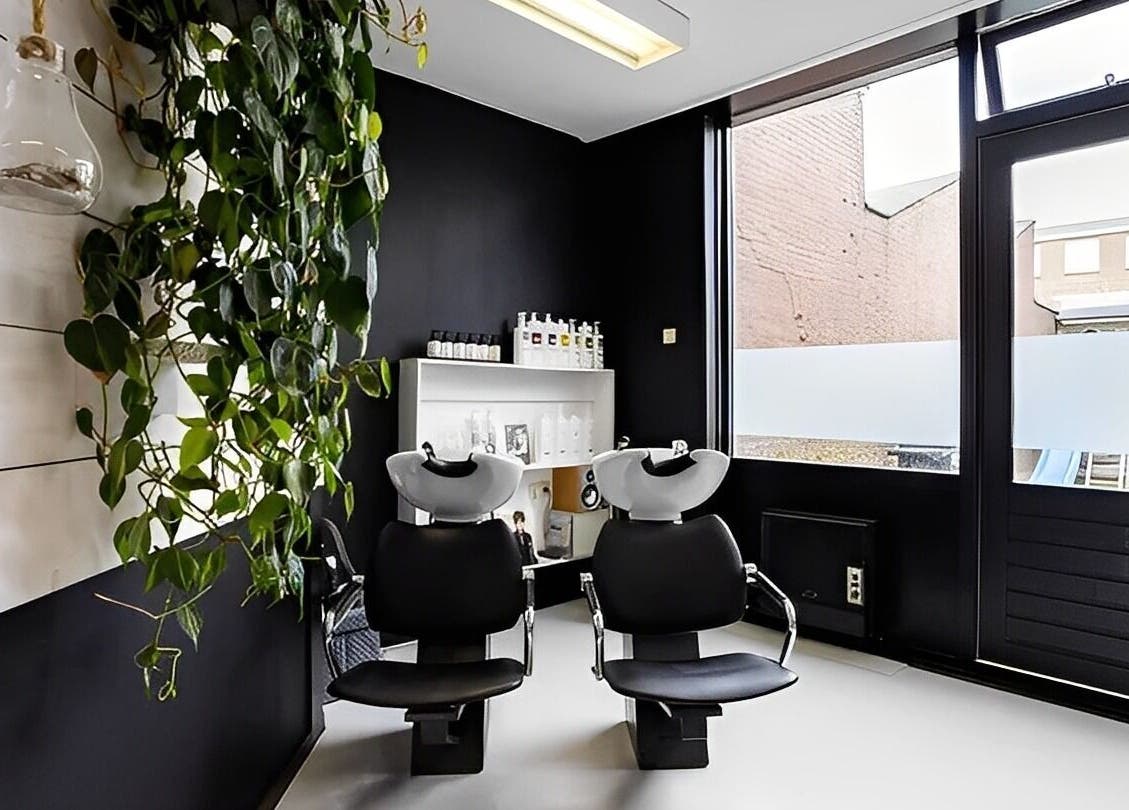 Stijlvolle wasruimte bij Mixt Haarsalon in Haarlem, Noord-holland, NL met moderne stoelen en groene accenten.