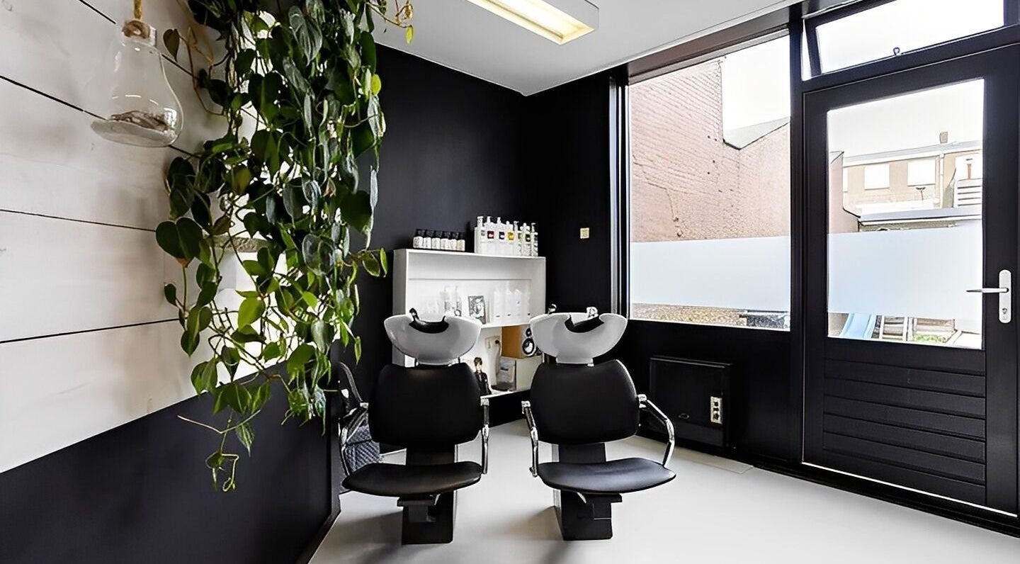 Stijlvolle wasruimte bij Mixt Haarsalon in Haarlem, Noord-holland, NL met moderne stoelen en groene accenten.