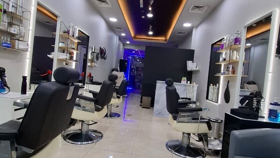 Modern interior of Sparkles N Charms Gents Salon in Dubai, AE showcasing sleek styling chairs and mirrors.