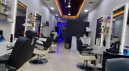 Modern interior of Sparkles N Charms Gents Salon in Dubai, AE showcasing sleek styling chairs and mirrors.