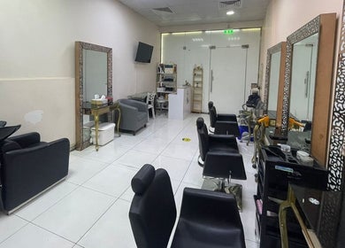 Spacious interior of Sparkles N Charms Womens Beauty Salon in Dubai, AE showcasing modern chairs and mirrors.