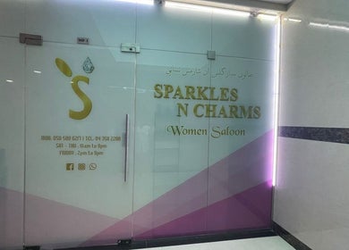 Entrance of Sparkles N Charms Womens Beauty Salon in Dubai, AE with modern glass doors and signage.