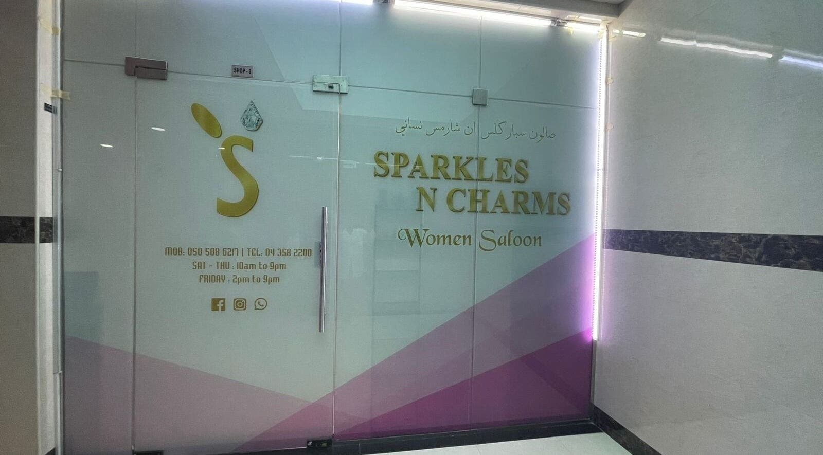 Entrance of Sparkles N Charms Womens Beauty Salon in Dubai, AE with modern glass doors and signage.