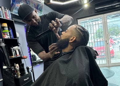 Gentlemen Barbershop & Hairstyling in Willemstad, Curaçao expertly styles a client's beard with precision.