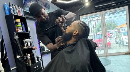 Gentlemen Barbershop & Hairstyling in Willemstad, Curaçao expertly styles a client's beard with precision.
