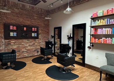 Modern salon chairs and product shelves at Elevate Hair Studio in De Pere, WI, US.