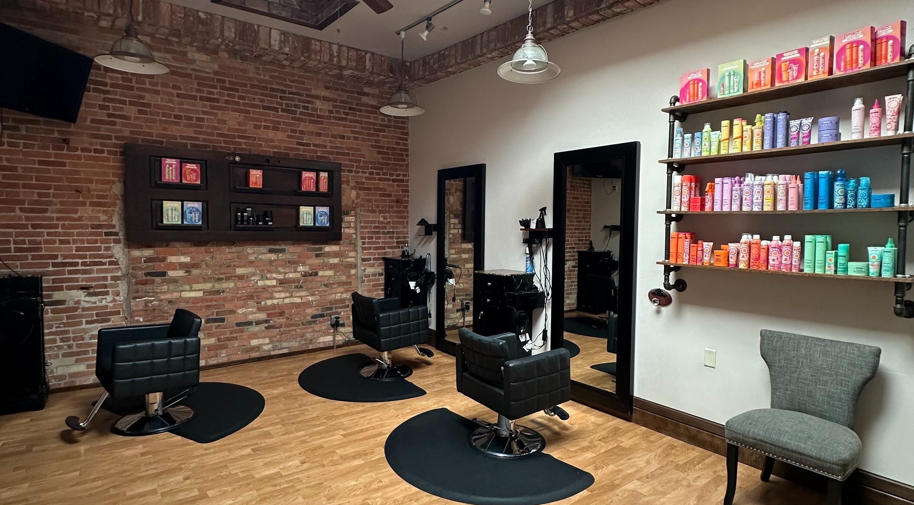 Modern salon chairs and product shelves at Elevate Hair Studio in De Pere, WI, US.