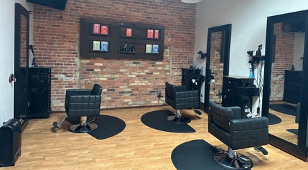 Modern salon interior at Elevate Hair Studio in De Pere, WI, US with stylish chairs and brick walls.