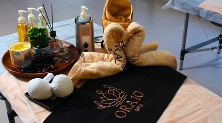 ORA10 SPA - Home Service in Riyadh features a calming treatment setup with oils, towels, and candles.