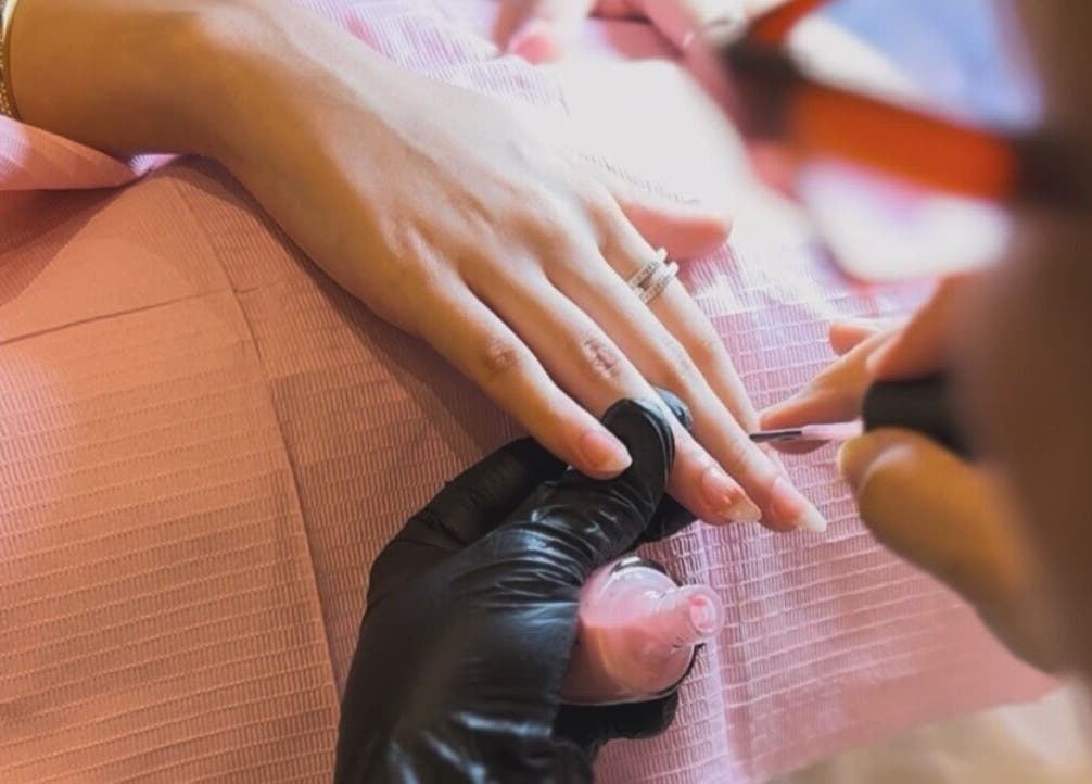 Nail technician at ORA10 SPA - Home Service in Riyadh polishing nails. Luxury spa experience in Riyadh Province, SA.