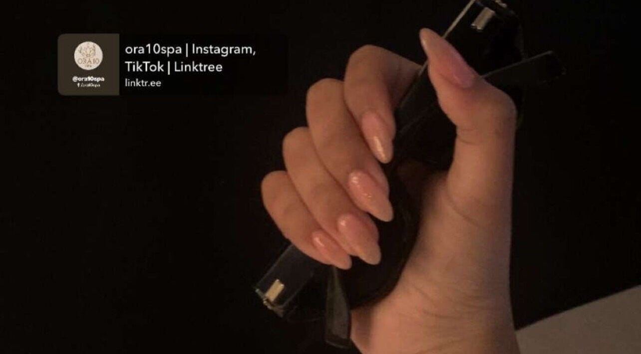 Elegantly manicured hand holding a black object at ORA10 SPA - Home Service, Riyadh, Riyadh Province, SA.