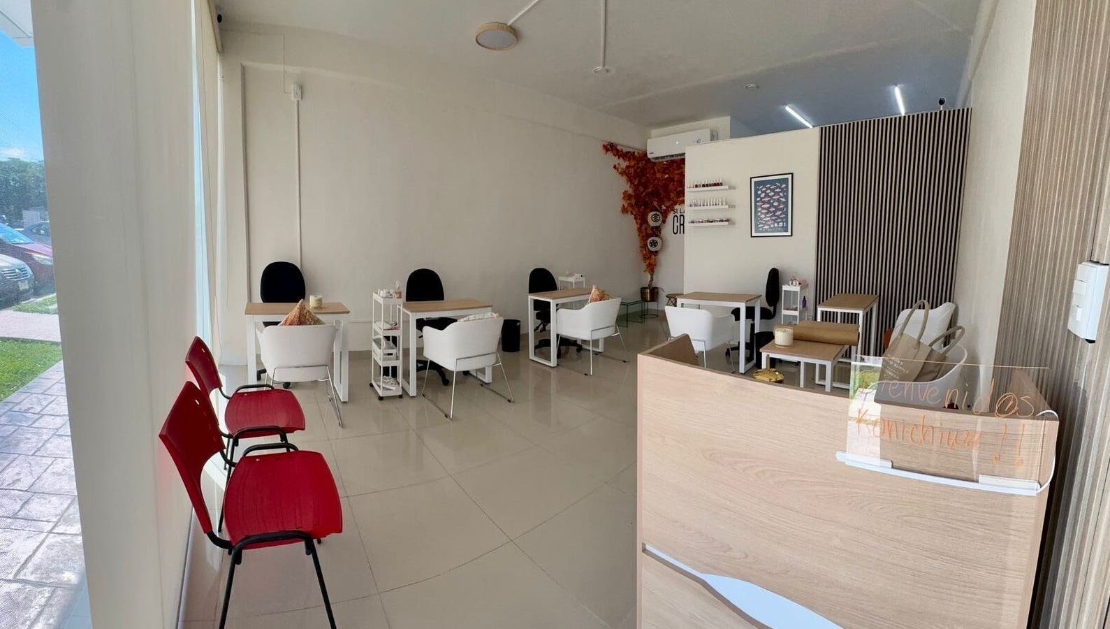 Interior moderno y acogedor de Momiji Nails Time en Mérida, Yucatán, MX con mesas y sillas blancas.