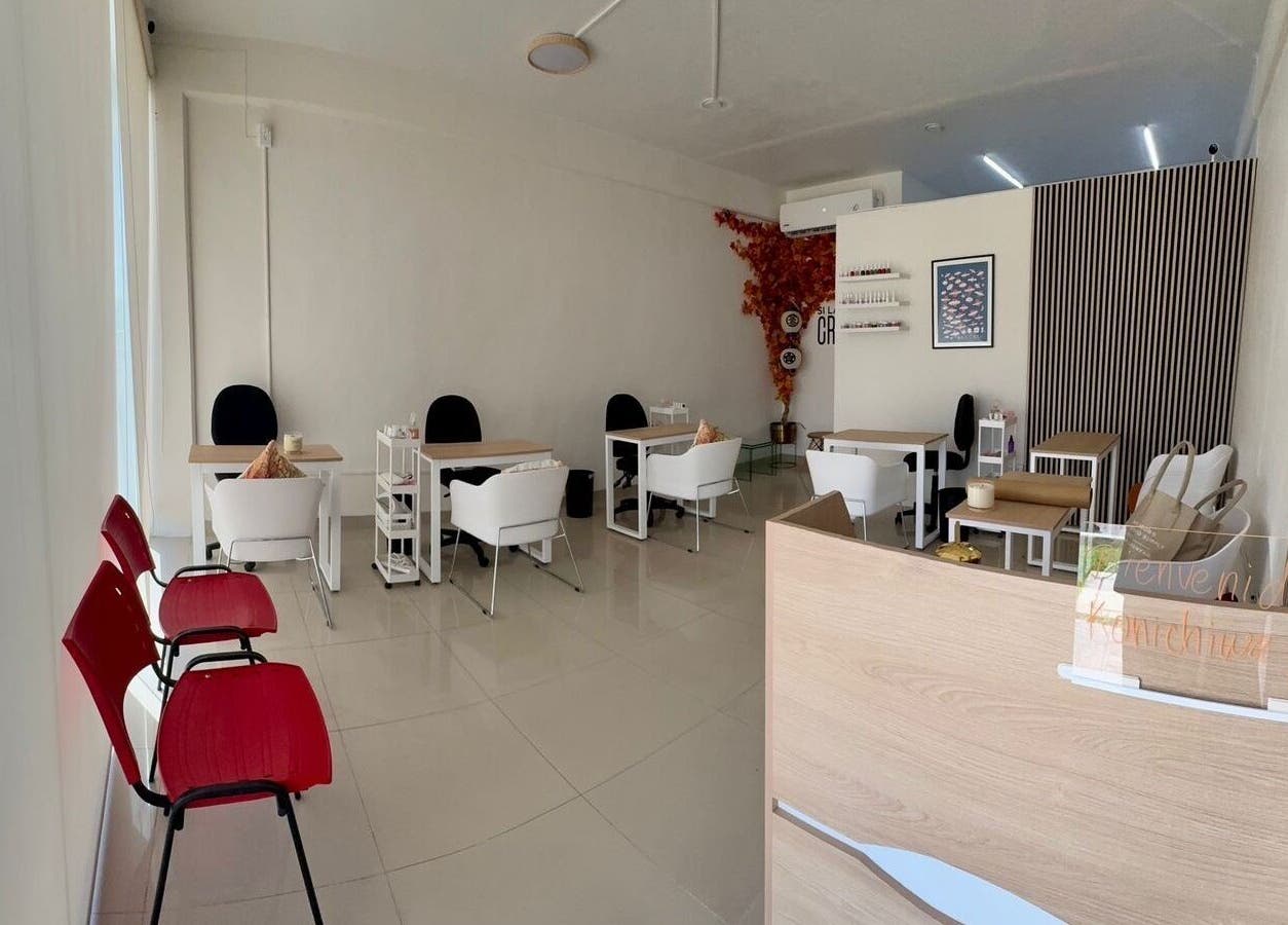 Interior moderno y acogedor de Momiji Nails Time en Mérida, Yucatán, MX con mesas y sillas blancas.