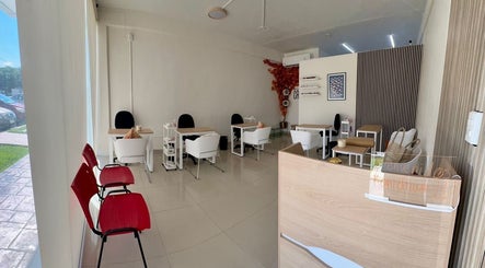 Interior moderno y acogedor de Momiji Nails Time en Mérida, Yucatán, MX con mesas y sillas blancas.