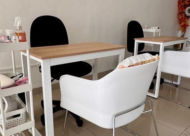 Espacio moderno de uñas en Momiji Nails Time, Mérida, Yucatán, MX, con sillas blancas y mesas elegantes.