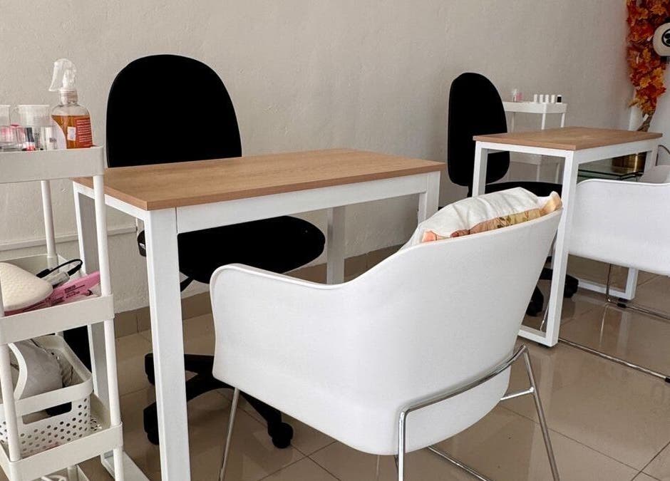 Espacio moderno de uñas en Momiji Nails Time, Mérida, Yucatán, MX, con sillas blancas y mesas elegantes.