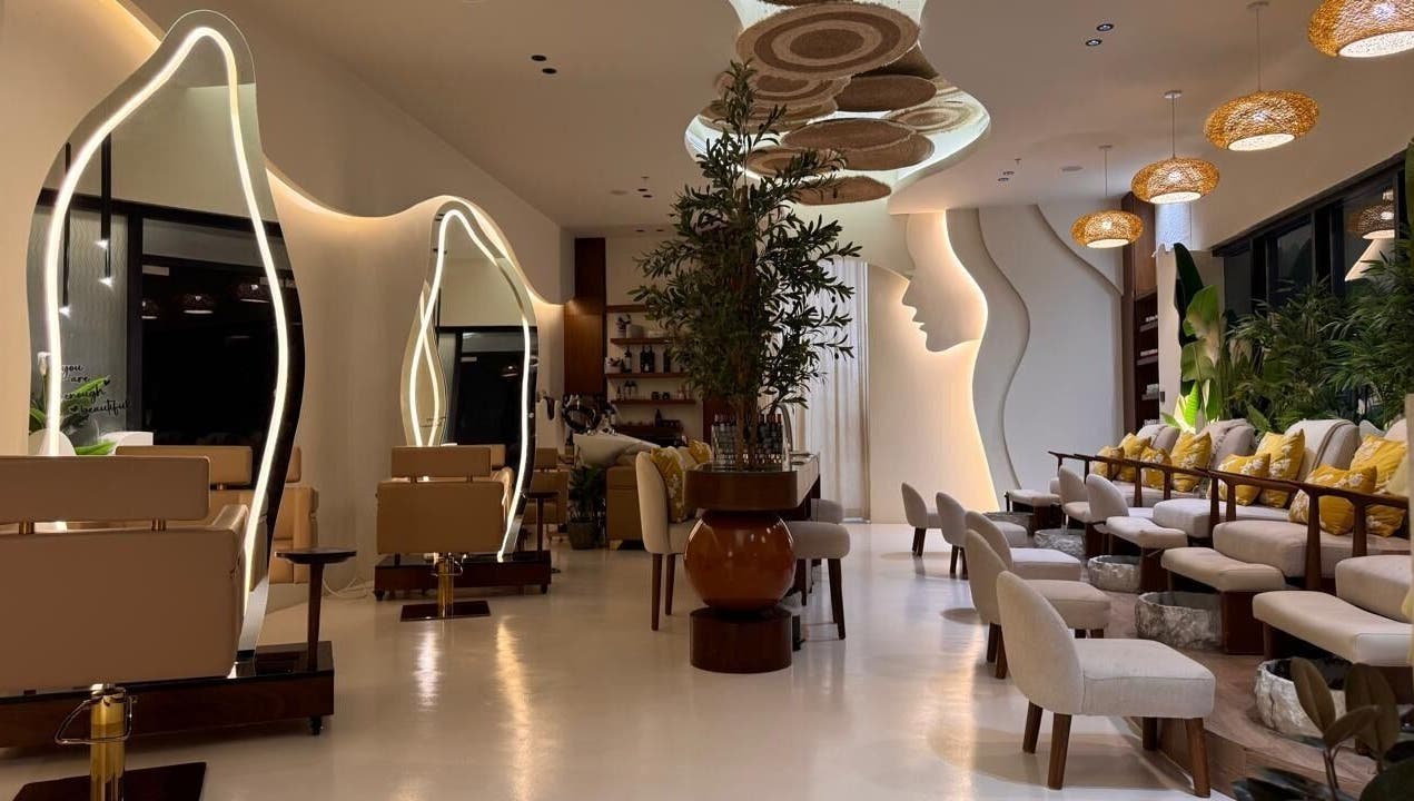 Elegant interior of Blend Spa, Sharjah, AE with modern seating, artistic mirrors, and lush greenery.