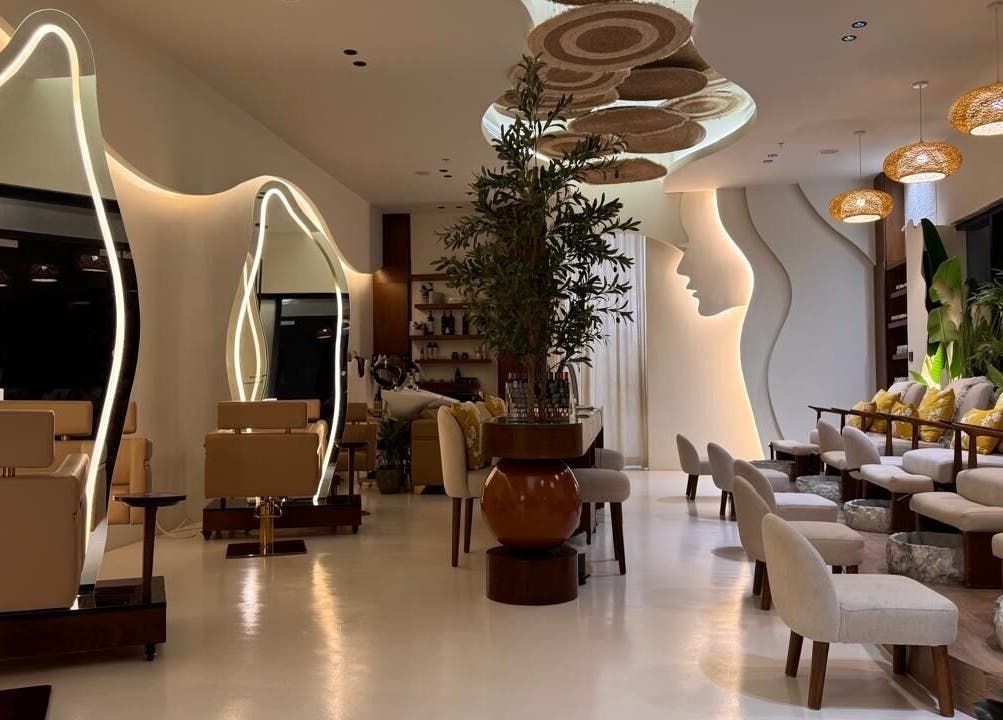 Elegant interior of Blend Spa, Sharjah, AE with modern seating, artistic mirrors, and lush greenery.