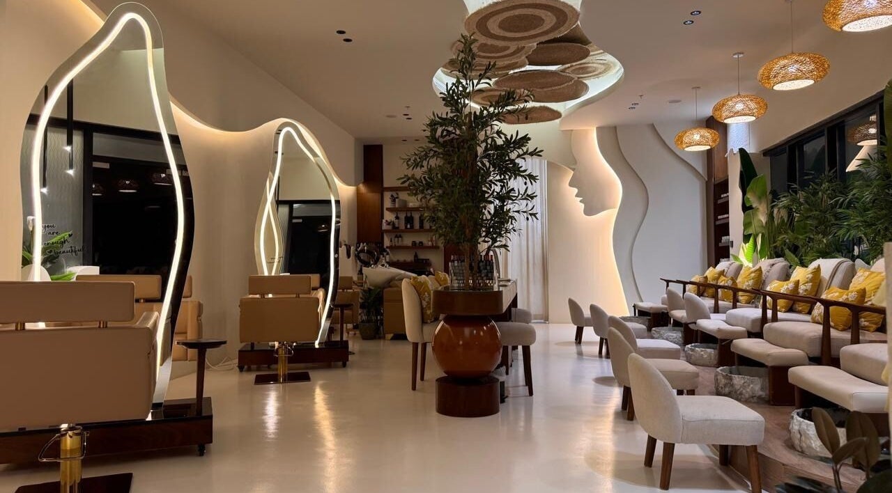 Elegant interior of Blend Spa, Sharjah, AE with modern seating, artistic mirrors, and lush greenery.