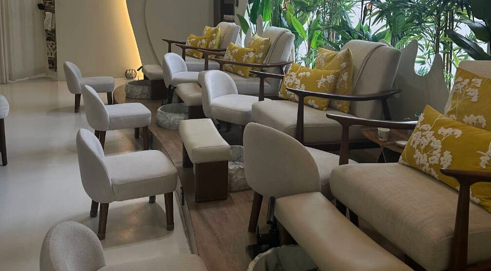 Luxurious pedicure chairs with cushions at Blend Spa, Sharjah, AE, surrounded by lush greenery.