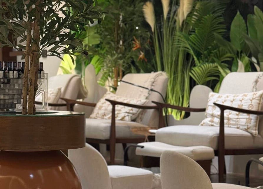 Relaxing seating area at Blend Spa, Sharjah, AE surrounded by lush greenery.
