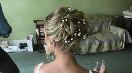 Stunning bridal updo with floral accents at DALA Hair Salon Ammanford, Ammanford, Wales, GB.