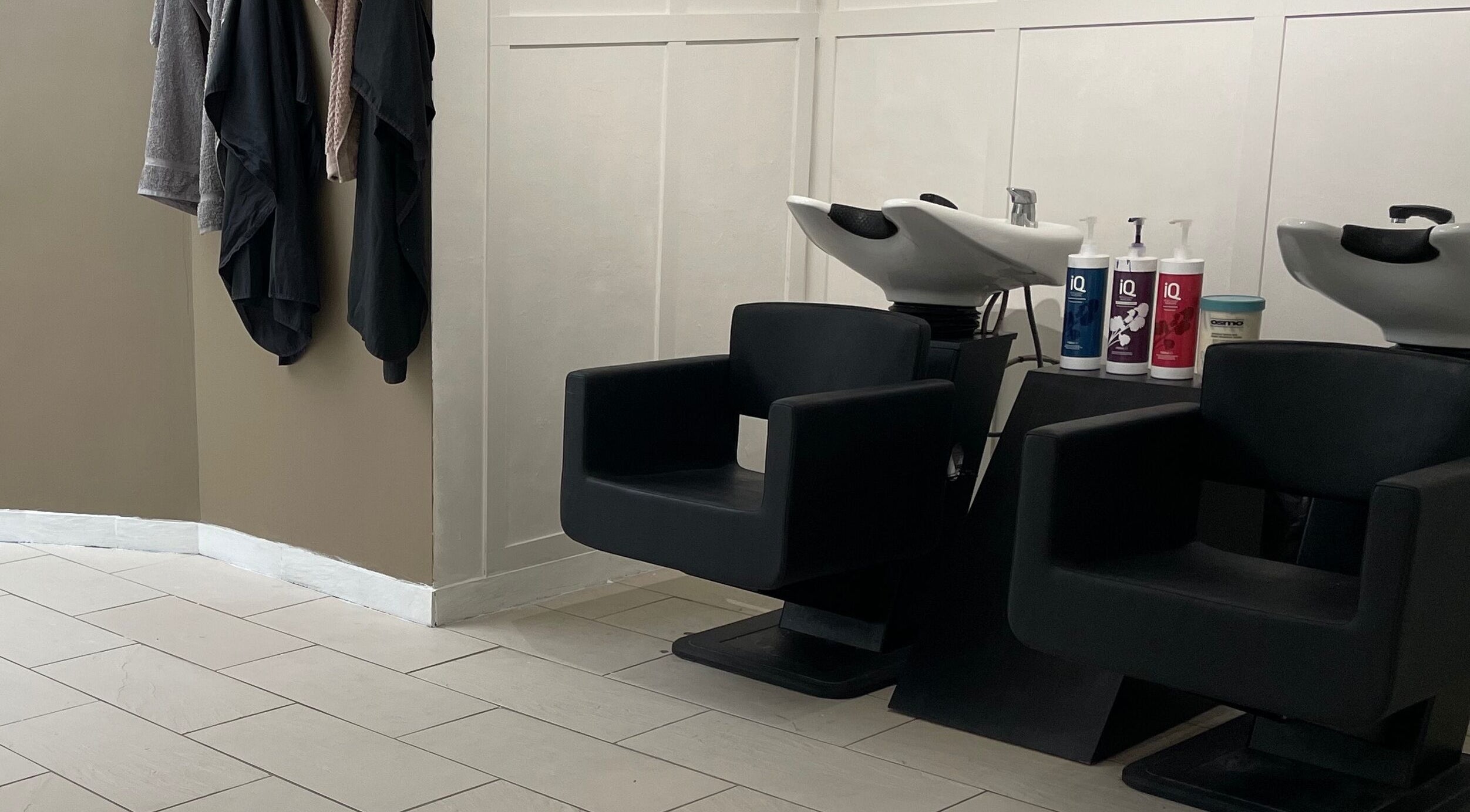 Modern wash stations at Dala Hair Salon Ammanford, Ammanford, Wales, GB, featuring sleek chairs and shampoo.