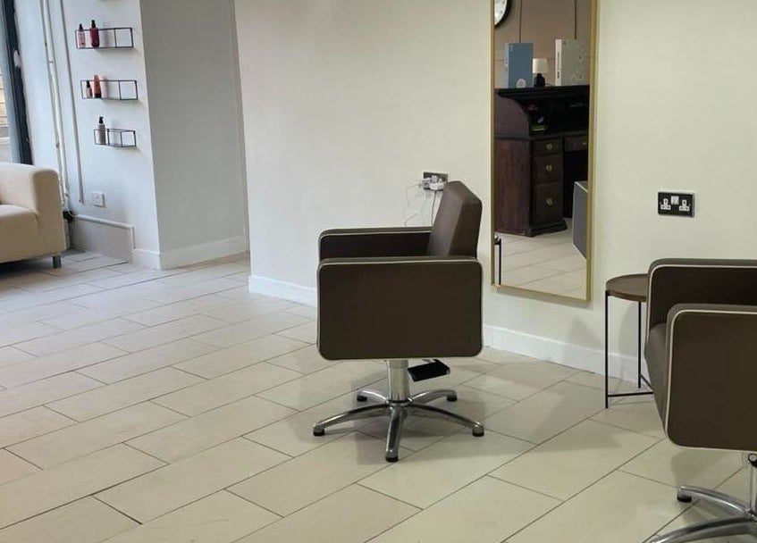 Modern seating area at Dala Hair Salon Ammanford, Ammanford, Wales, GB with stylish brown chairs and a cozy sofa.