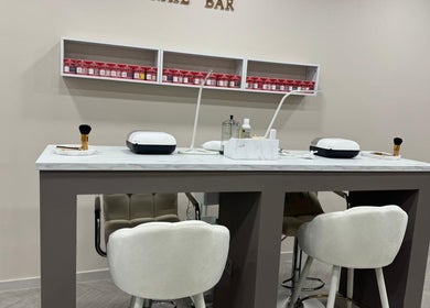 Elegant nail bar setup at Bisou Studio, Manchester, England, GB featuring plush seating and grooming tools.