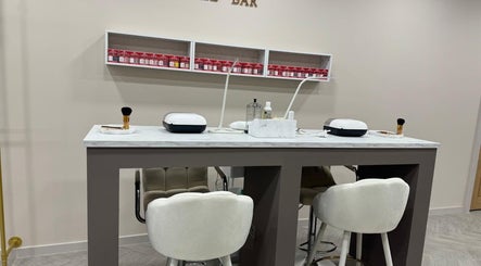 Elegant nail bar setup at Bisou Studio, Manchester, England, GB featuring plush seating and grooming tools.