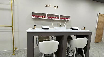 Elegant nail bar at Bisou Studio in Manchester, England, GB, featuring modern chairs and manicure stations.