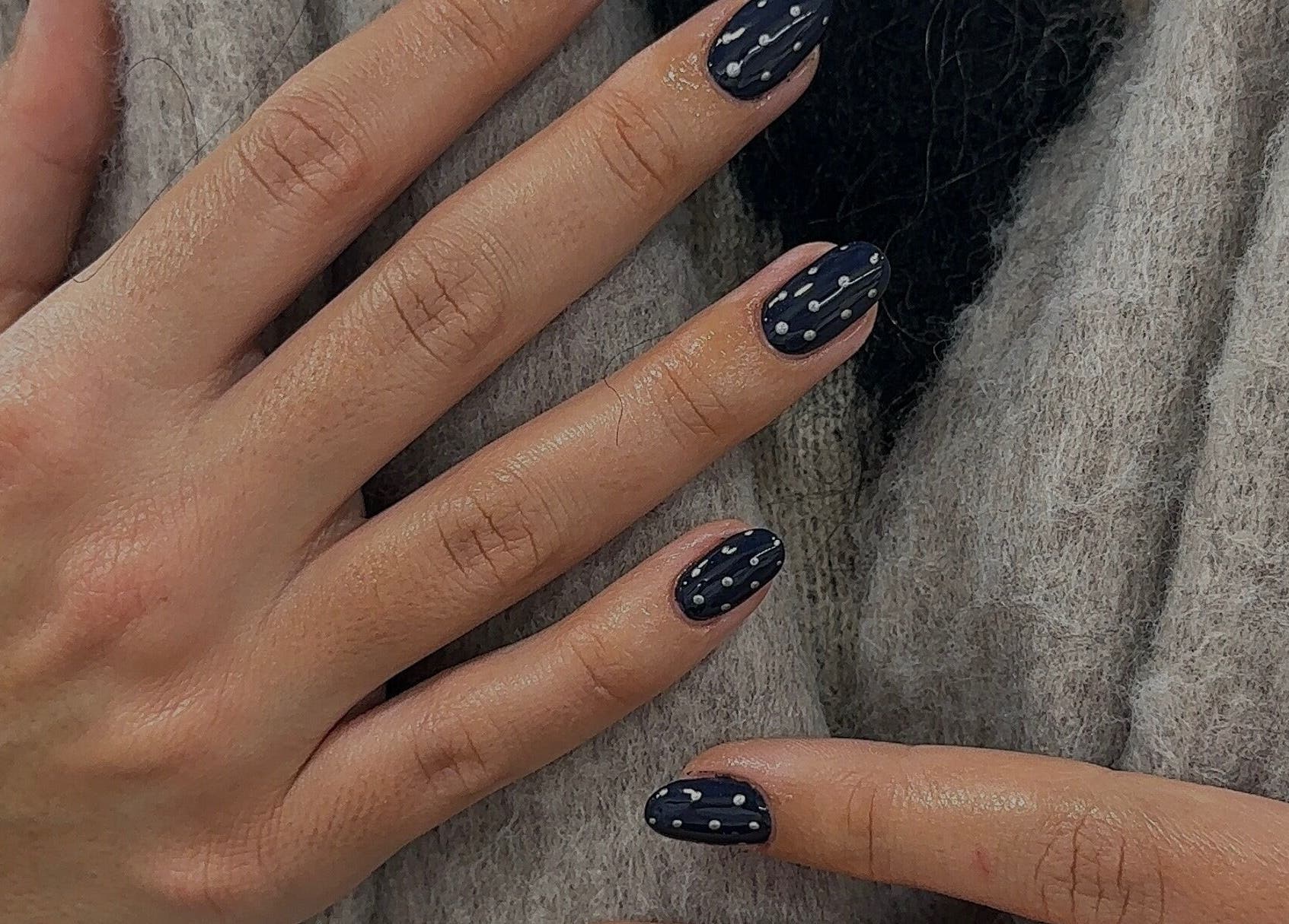 Polka dot nail art at Bisou Nail Studio, Manchester, England, GB. Chic black design with white dots.