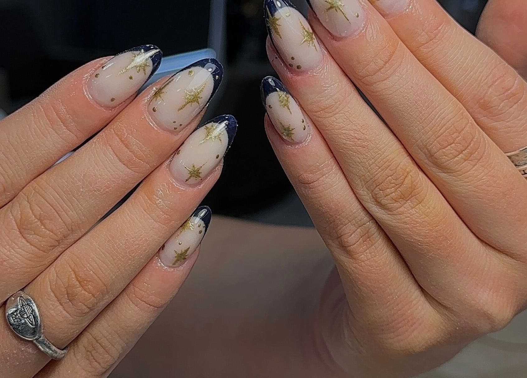 Elegant starry nail art at Bisou Nail Studio, Manchester, England, GB. Featuring dark tips and gold accents.