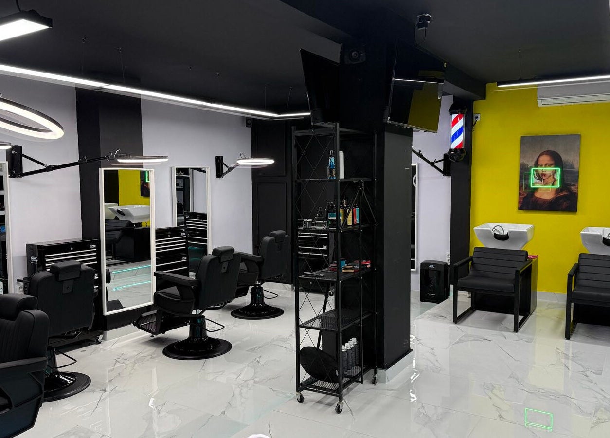 Σύγχρονος εσωτερικός χώρος στο Anestis Barber, Αγία Βαρβάρα, GR με κομμωτικά εργαλεία και χώρους αναμονής.