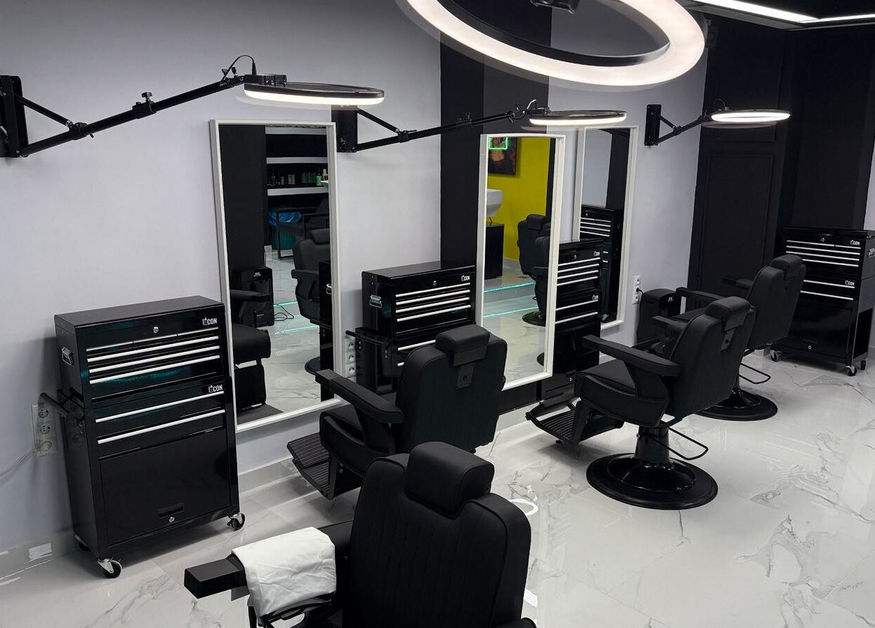 Κομψό εσωτερικό του Anestis Barber στην Αγία Βαρβάρα, GR με μοντέρνες καρέκλες και φωτιστικά.